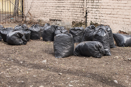 花园里堆垃圾塑料袋，垃圾袋废物造成的污染，垃圾袋塑料堆，垃圾袋塑料黑很多，堆垃圾袋