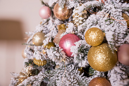 圣诞树装饰着金色和粉色的玩具。