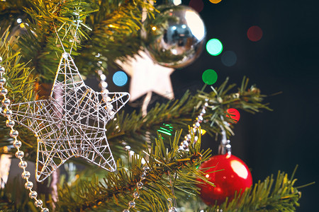 美丽的圣诞装饰概念，挂在圣诞树上的小玩意，闪闪发光的光点，模糊的深黑色背景，宏观细节，特写。