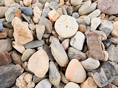 圆传统纹理摄影照片_由天然砾石、干燥的圆形和彩色鹅卵石制成的旧石质路面。