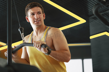 年轻的健美运动员在健身房为二头肌做大重量训练