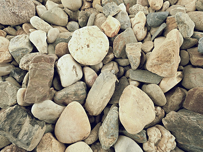 圆传统纹理摄影照片_由天然砾石、干燥的圆形和彩色鹅卵石制成的旧石质路面。