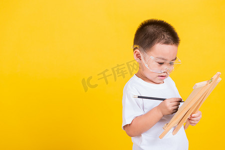 孩子彩色铅笔摄影照片_孩子男孩微笑正在黑板上画画