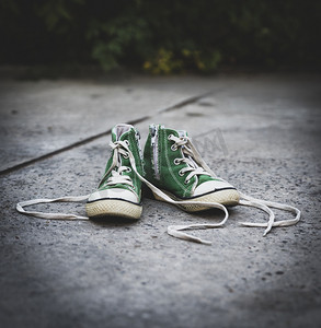 绿色经典摄影照片_带解开鞋带的旧纺织儿童绿色经典运动鞋