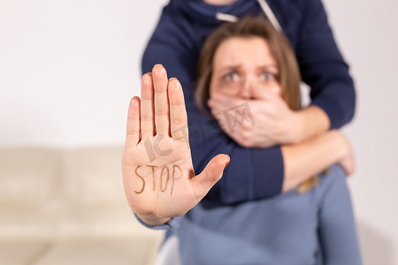 酗酒、虐待和问题概念-悲伤的女人显示停止标志，停止家庭暴力。
