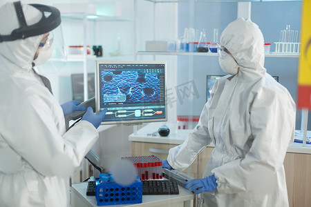 面罩摄影照片_在微生物医院实验室工作的穿着医疗防护服的生物学家科学家