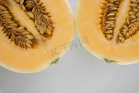 甜橙摄影照片_白盘上的新鲜甜橙瓜作为背景，有选择性地聚焦。