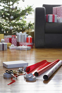硬木地板上的圣诞包装纸和配件