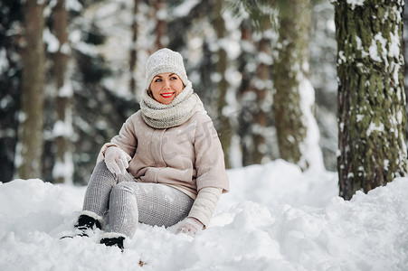 冬天森林里一个穿着灰色衣服的女人的画像。新年白雪覆盖的森林里的女孩。