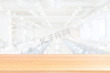 空的木桌地板在模糊的白色食堂餐厅房间背景，木桌板空的前面吃食物在大学食堂模糊背景，木板空白在食堂白色软