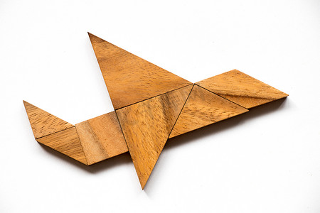 摘要背景摄影照片_白色背景飞机形状的木制七巧板拼图 (Con
