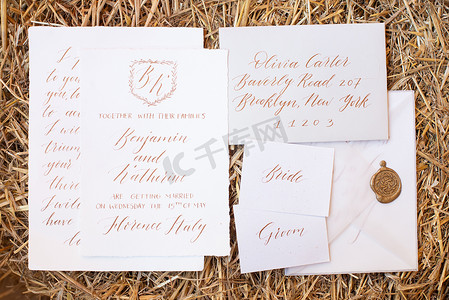 婚礼邀请函摄影照片_婚礼细节平躺在木制的背景上。
