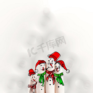 手绘雪人可爱摄影照片_一个可爱的家庭手绘和雪人的手指在模糊的背景上