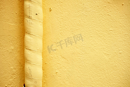 管网设计摄影照片_黄漆混凝土墙上的空气管道。