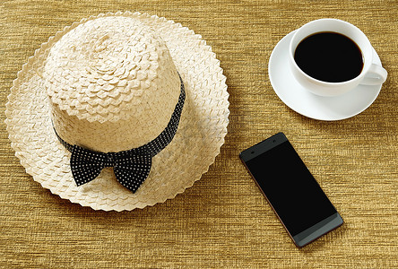 一顶帽子和一杯咖啡，以及放在工作区的电话。