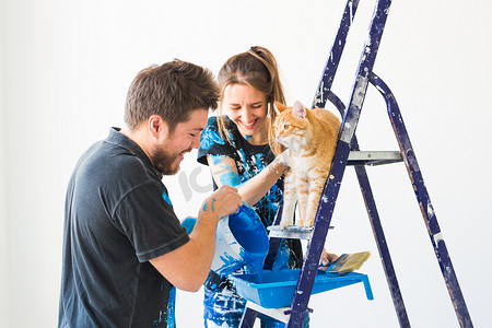 人、翻新和维修概念 — 幸福夫妻与猫倒漆的肖像