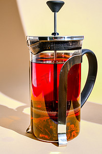 带热芙蓉茶的玻璃茶壶 新鲜酿造的辛辣果茶，配香草、玫瑰花、黄色背景的热健康饮料，带文字复制空间