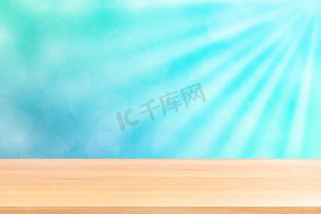 空木桌地板上柔和的蓝色散景灯光束闪耀渐变背景，蓝色散景上空的木板彩色灯光闪耀，彩色散景灯渐变柔和，用于横幅广告