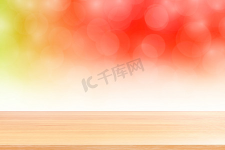 空木桌地板在模糊的散景柔和的红色白色渐变背景上，木板空在红色散景彩色光罩上，彩色散景灯渐变软，用于横幅广告产品