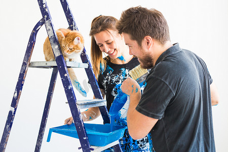 装修壁纸摄影照片_人、重新装修和关系概念 — 年轻有趣的夫妇带着猫在新公寓装修