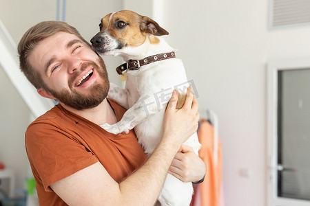 动物、宠物和人的概念 — 穿着休闲芥末 T 恤、带着杰克罗素梗犬的微笑男人