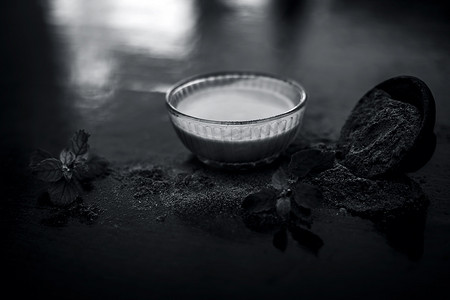有益的摄影照片_Ayurvedic 草本 brahmi 或 Waterhyssop，将其有益的糊状物放入玻璃碗中，并在木质表面上涂上粉末。