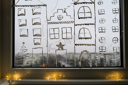 装饰画摄影照片_圣诞假期装饰画在窗玻璃上。