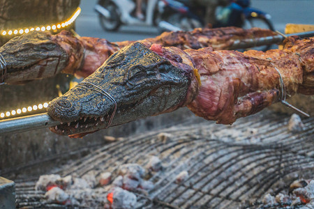 在海鲜餐厅的明火上烤鳄鱼，越南异国情调的美食，亚洲美食，生鳄鱼肉。