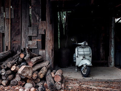 白色老式 Vespa 摩托车停在木屋里。