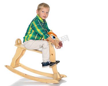 一个小男孩骑着一匹木马
