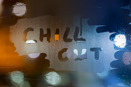 chill out on wet glass 的文字是用手指写的，背景是模糊的灯光