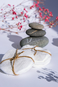 白色背景玄武岩石堆卸妆用生物有机棉可重复使用圆垫.