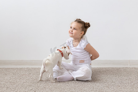 宠物主人、孩子和狗的概念 — 小女孩和可爱的杰克罗素梗小狗坐在地板上玩耍