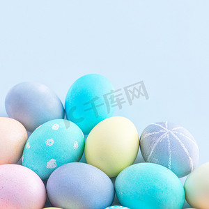 五颜六色的复活节彩蛋由淡蓝色背景上的彩色水染成，复活节假期活动的设计理念，特写，复制空间。