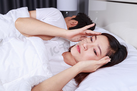 在床上失眠并在卧室里有偏头痛、压力、失眠、宿醉的妇女