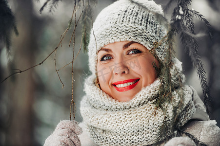 冬天森林里一个穿着灰色衣服的女人的画像。新年白雪覆盖的森林里的女孩。