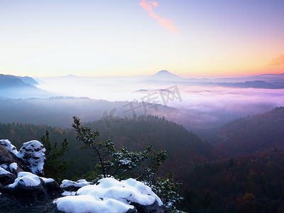 冻结秋天的黎明，岩石上覆盖着新鲜的粉雪。