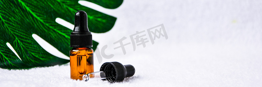 滴管玻璃瓶护肤精油产品，用于在白色背景和蒙斯特拉叶上以极简风格进行模拟。