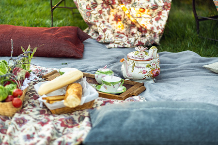 坐在草地摄影照片_法国普罗旺斯日落时草坪上美丽的野餐点
