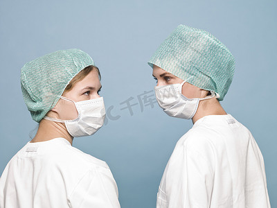 戴口罩的科学家摄影照片_两名戴着医用口罩的护士