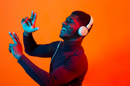非洲年轻人戴着耳机听音乐的霓虹画像。