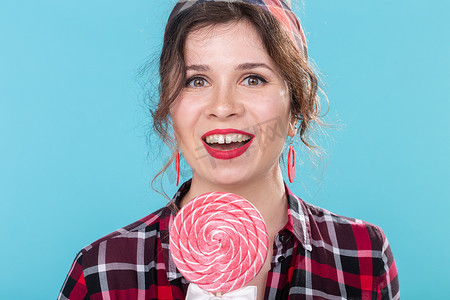 饮食、甜点和垃圾食品 — 蓝色背景复制空间上带有棒棒糖的特写女性海报风格。