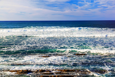 溅起的浪花摄影照片_与岩石、泡沫和浪花浪花的海景