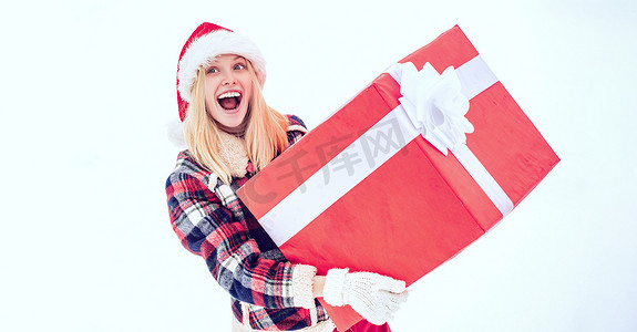 疯狂购物海报摄影照片_拿着巨大的红色礼物的圣诞老人女人看着相机。