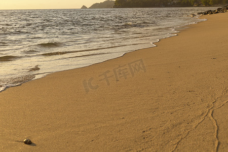 沙滩背景摄影照片_来自大海的软波来到湿沙滩背景。