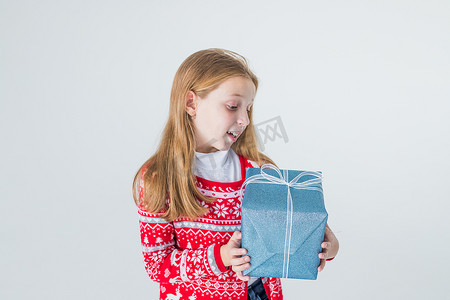 快乐的小女孩，长发打开盒子，圣诞礼物，孤立在白色背景中。快乐的英俊女孩手里拿着带蝴蝶结的礼物，微笑着。复制空间