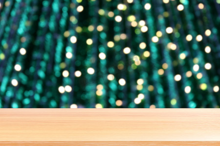 绿色桌面背景摄影照片_木板照明模糊圣诞树装饰背景，空木桌地板照明绿色圣诞散景，木桌板空前绿色闪光背景浅色
