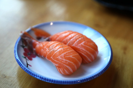 白色黑景摄影照片_木背景上的三文鱼寿司