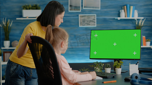 学习屏摄影照片_母亲和女儿在电脑上看水平绿屏