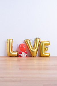 情人节、母亲节设计理念 — 浅色木地板和白墙背景上带有爱字形状的漂亮气球，特写